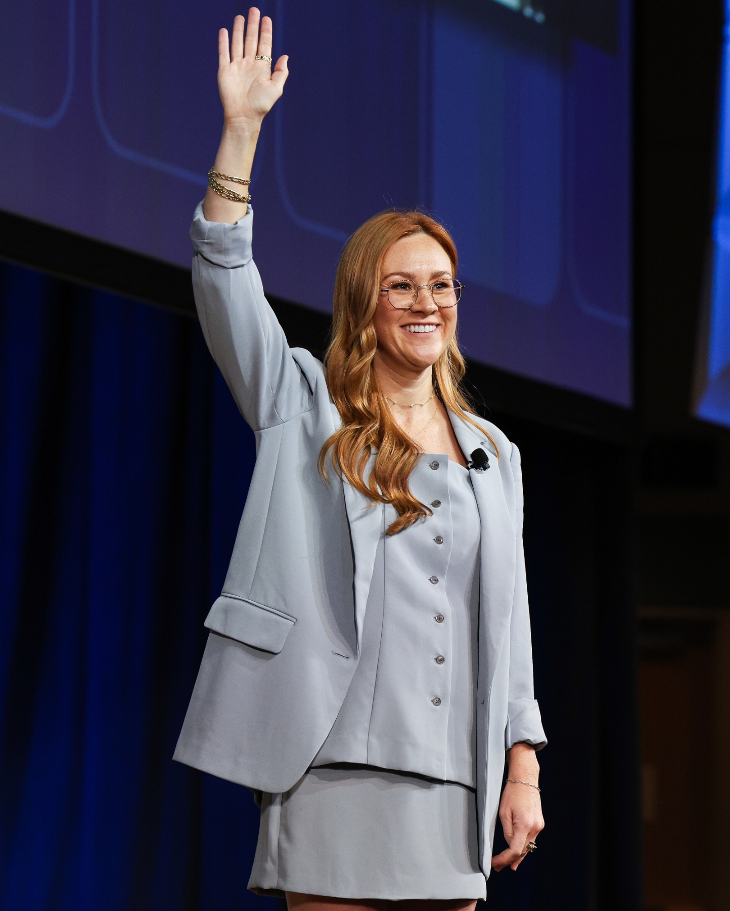 Keynote speaker waving to the audience on the ASHE HFIC main stage