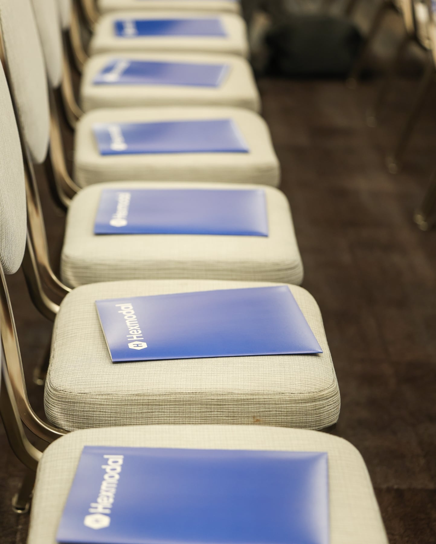 Hexmodal welcome folders placed on seats before a session